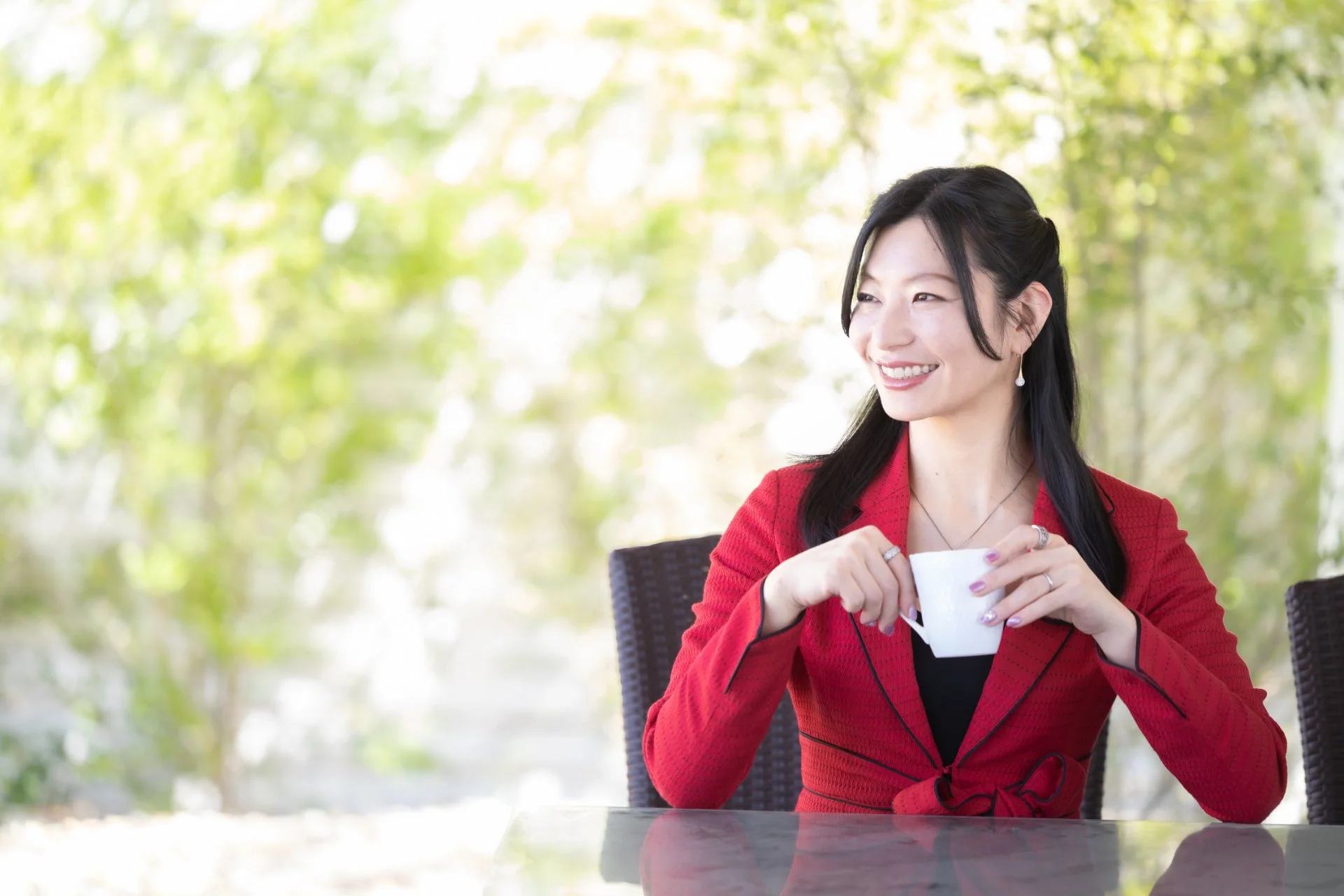 木の床と大きな窓があるヨガスタジオの室内で、マットを整える前景がある写真